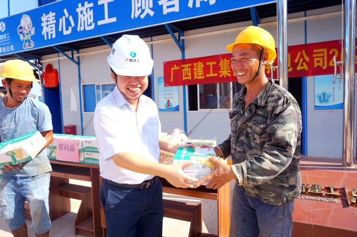 岑廷義為工人發(fā)放清涼慰問品。謝微旋 攝.jpg